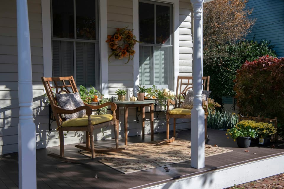 Rocking chairs on the front porch of an older clapboard house in autumn